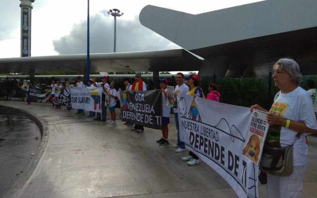 Con pancartas, venezolanos esperan en aeropuerto de Cancún a delegaciones de la OEA