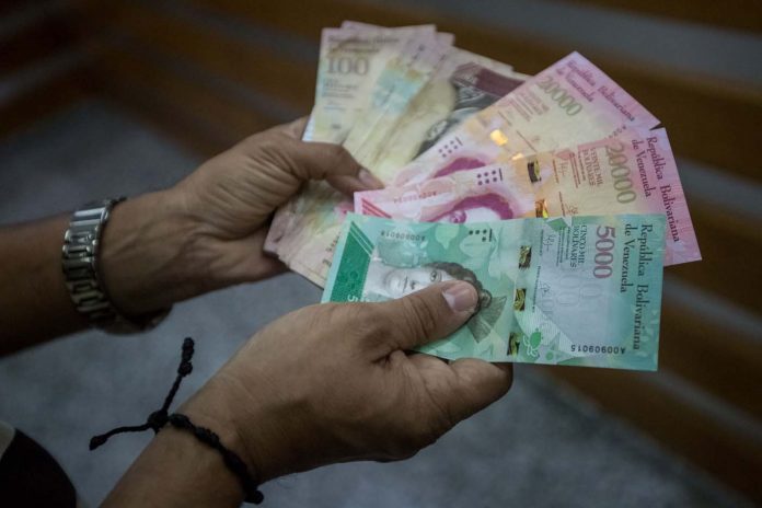 Venezolanos compran billetes en la calle para poder tener efectivo